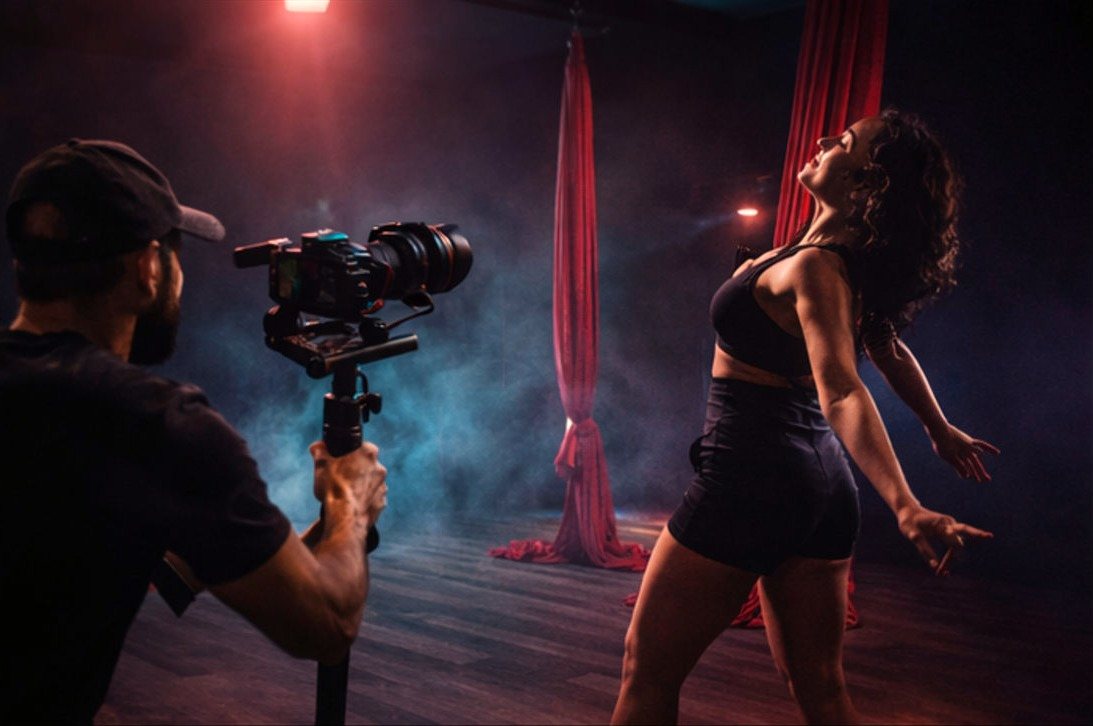 Videographer filming a dancer on aerial silks at YUX Studio